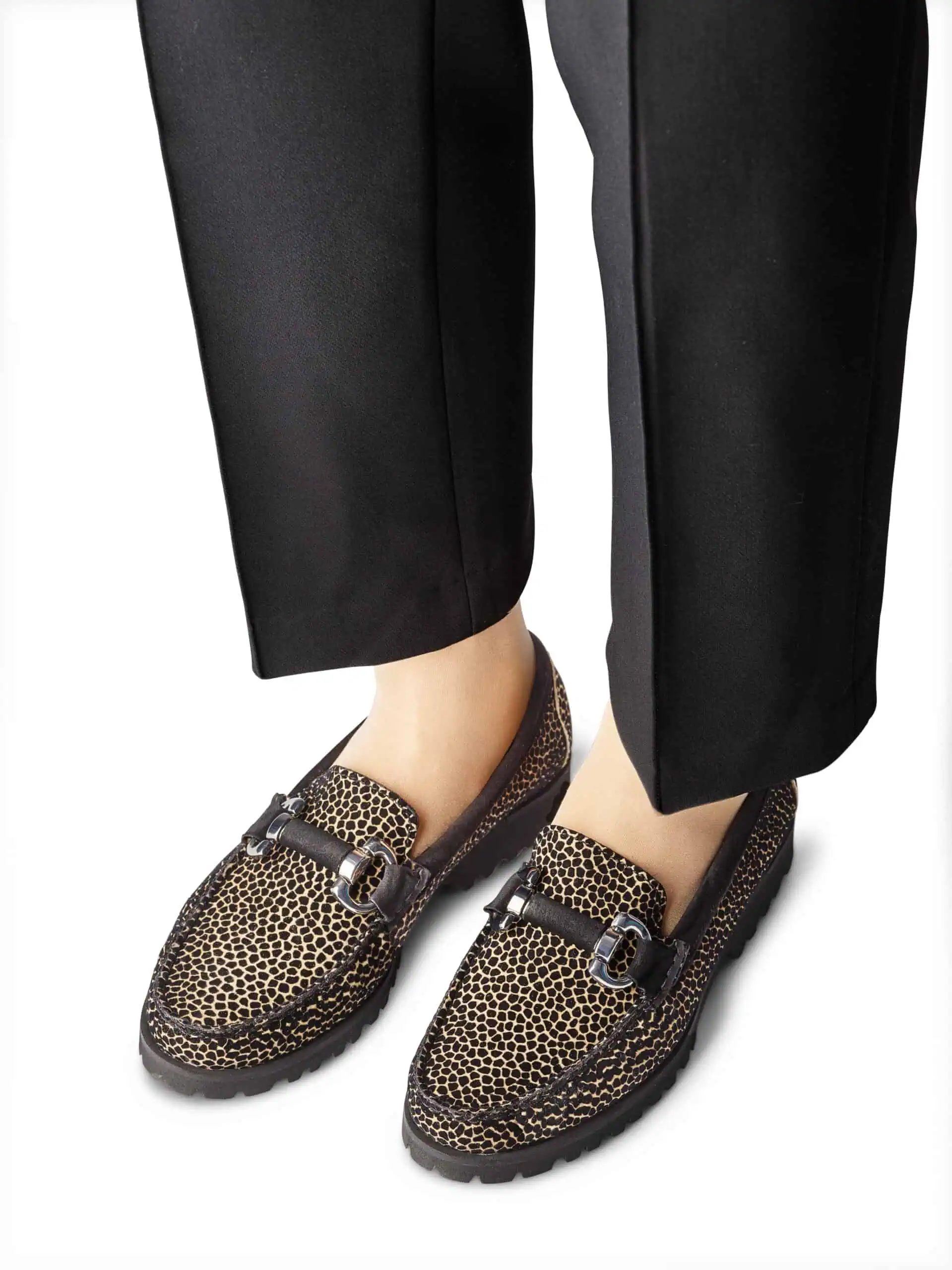 Detaljerad bild av leopardmönstrade loafers för kvinnor.
