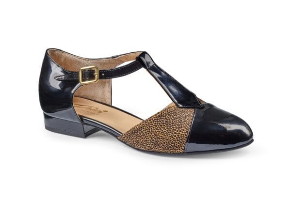 Läder- och textilskor för kvinnor med låg klack och T-strapsdesign.