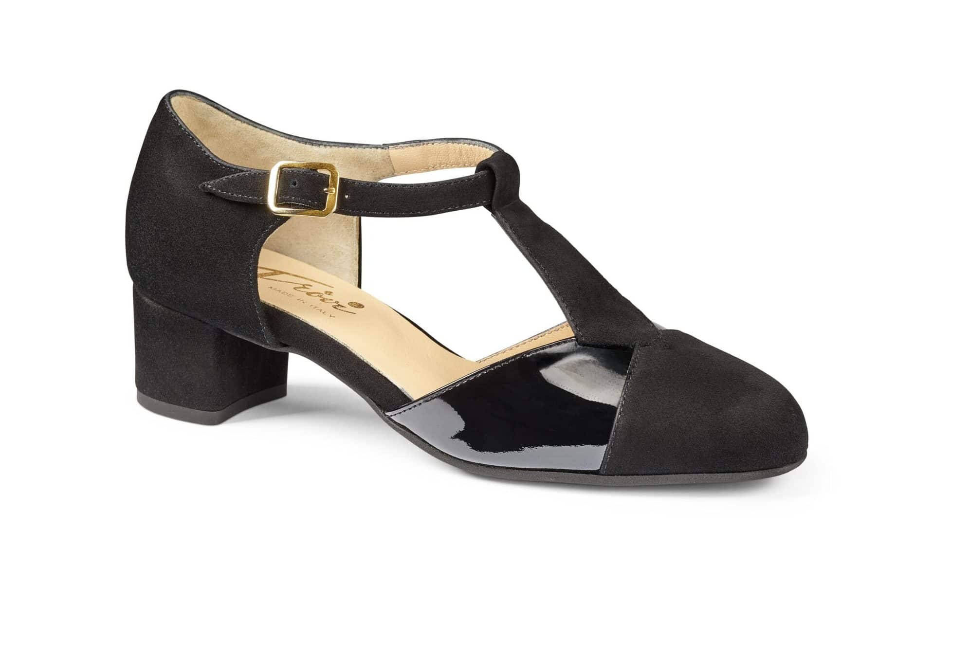 Svart damtillhörande sko med låg klack och T-strapsdesign.