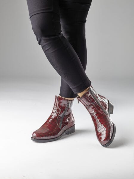 Röd lackskinnstövel med krokodilmönster och zipp.